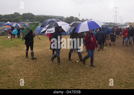 Gruppe mit großen Sonnenschirmen auf dem Glastonbury Festival 2013, Somerset, England, Vereinigtes Königreich. Stockfoto