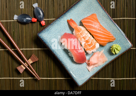 Gemischte Sushi Platte, Garnele, Lachs und Thunfisch mit Ingwer und Wasabi auf Bambus Matte Stockfoto