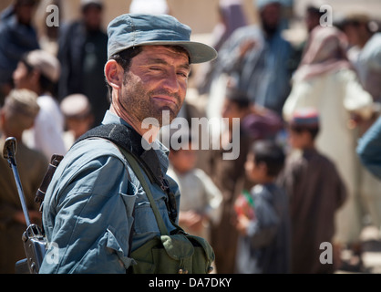 Eine afghanische nationale zivile Ordnung Polizist bietet Sicherheit während einer Verteilung von Radios und Comic-Bücher für die Bewohner 26. Mai 2013 in Delaram, Provinz Helmand, Afghanistan. Stockfoto