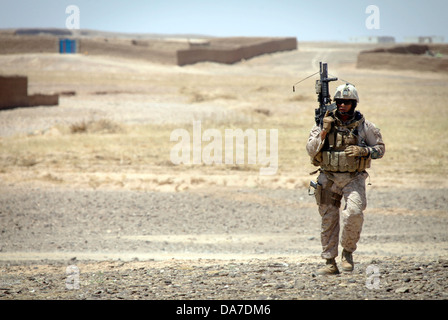 Ein US-Marine bietet Sicherheit bei einer Verteilung von Radios und Comic-Bücher für die Bewohner 26. Mai 2013 in Delaram, Provinz Helmand, Afghanistan. Stockfoto