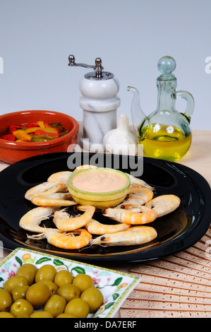 Spanische Tapas, bestehend aus König Garnelen (Langusten) mit Fisch-Soße, grüne Oliven, gebratene Paprika in Olivenöl gemischt. Stockfoto