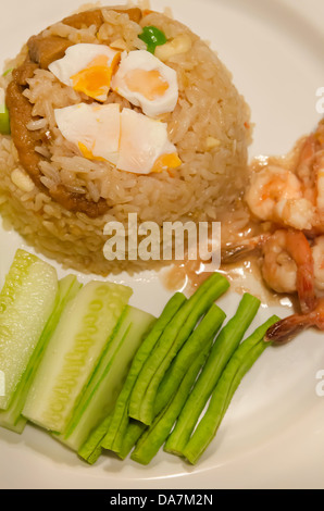 Draufsicht gebratenen Reis mit Chili-Sauce, gekochtes Ei, Schweinefleisch und Garnelen serviert mit frischem Gemüse Stockfoto