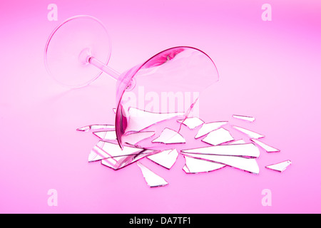 Konzept-Foto der zerbrochene Beziehung mit gebrochenen Martini-Glas und zerbrochene Spiegel gedreht auf Leuchttisch mit rotem Licht Stockfoto