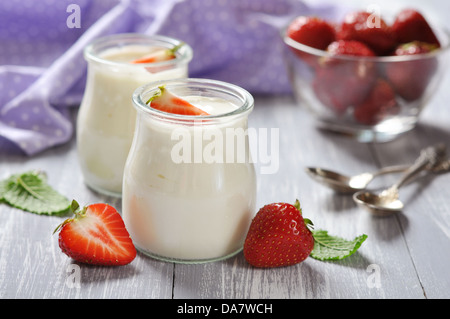 Joghurt mit Reife frische Erdbeere in Gläsern auf hölzernen Hintergrund Stockfoto