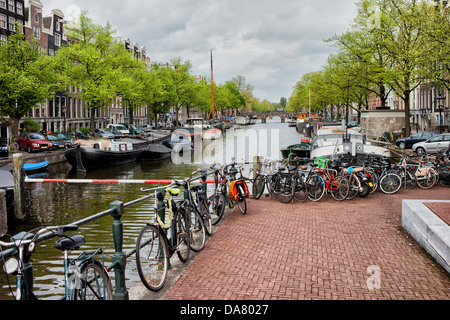 Fahrräder und Boote auf dem Kanal in Amsterdam, Niederlande, Provinz Nordholland. Stockfoto