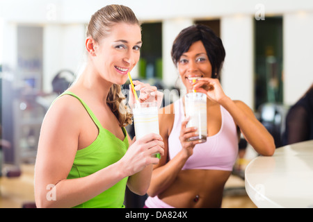 Junge Menschen - Frauen in der Turnhalle einen isotonischen Getränk oder Protein-Shake trinken Stockfoto