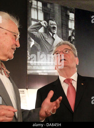 Riga, Lettland. 7. Juli 2013. German President Joachim Gauck (R) besucht das Okkupationsmuseum und hört an den Vorsitzenden des Kuratoriums, Otto Nollendorfs, in Riga, Lettland, 7. Juli 2013. Ein Porträt des deutschen Diktators Adolf Hitler hängt im Hintergrund. Foto: WOLFGANG KUMM/Dpa/Alamy Live News Stockfoto