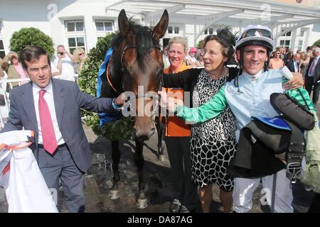 Trainer Peter Schiergen, Besitzer Ingeborg von Schubert und Jockey Andrasch Starke feiert Derby-Sieg neben Rennpferd Lucky Geschwindigkeit während der 144. Deutsches Derby am Horner Rennbahn in Hamburg, Deutschland, 7. Juli 2013. Das Galopp-Rennen ist mit 500.000 Euro dotiert. Foto: MALTE Christen Stockfoto