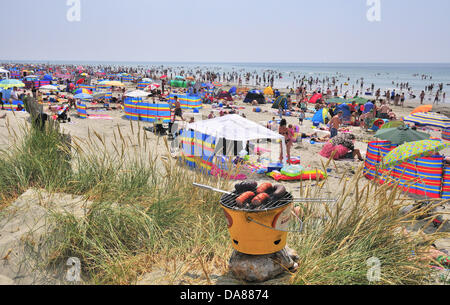 West Wittering, West Sussex, UK. 7. Juli 2013. Sizzling Sonntag als Tagesausflügler an den beliebten West Wittering Strand nehmen um sich abzukühlen, als die Temperaturen auf 30 Grad im Landesinneren in Südengland 2. Parkplatz geöffnet, um Platz für bis zu 10.000 cars.iPhones und iPads waren bereit zu streamen von Wimbledon Tennis in den Strand Zelten und unter Sonnenschirmen Credit: Gary Blake/Alamy Live News Stockfoto