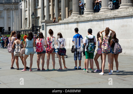 Gruppe von männlichen und weiblichen Studenten beobachten Streetart-Künstler in die National Gallery am Trafalgar Square in London Stockfoto