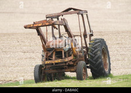 Alten Bauernhof Traktor weggelassen, um bei Regen und schlechtem Wetter zu rosten, hat starke Korrosion einen Griff der Traktoren Metallkörper übernommen Stockfoto