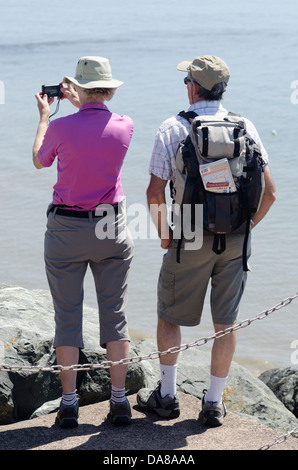 Zwei Touristen, Mann und Frau, gekleidet in Wanderausrüstung anzeigen Websites bei Lyme Regis Dorset. Stockfoto