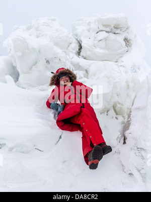 Frau spielt unter die Eisblöcke erstellt von Gezeiten Aktion am Rande der Hudson Bay im Spätwinter. Churchill, Manitoba, Kanada. Stockfoto