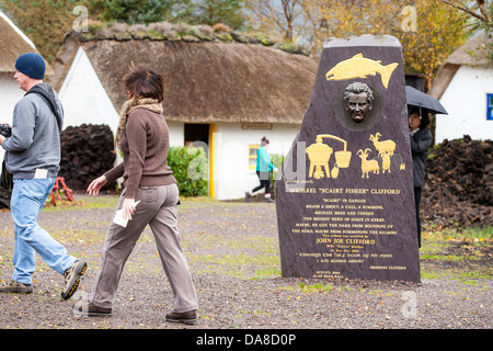 Besucher gehen vorbei ein Denkmal, ein Wilderer im Kerry Bog Village in Co Kerry in Irland Stockfoto