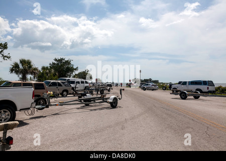 Fahrzeuge und Bootsanhänger parken entlang der Straße zur öffentlichen Bootsrampe und dock nahe Yankeetown, Florida. Stockfoto