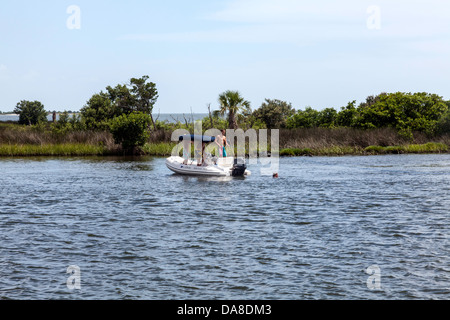 Mann ein kleines aufblasbares Wasserfahrzeug besetzt von drei Männern in den Withlacoochee River in der Nähe von Yankeetown, Florida schwimmen. Stockfoto