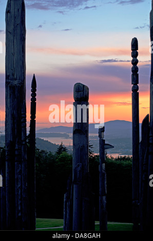 Silhouetten der japanischen Ainu hölzerne Totems auf dem Burnaby Mountain bei Sonnenuntergang. Teil der "Spielplatz der Götter". Vancouver in der Ferne. Stockfoto