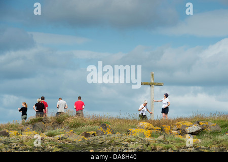 Menschen besuchen St. Cuthbert Isle hölzernen Kreuz auf Holy Island, Lindisfarne, Northumberland, England Stockfoto