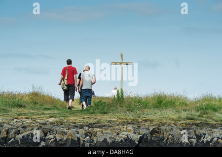 Menschen besuchen St. Cuthbert Isle hölzernen Kreuz auf Holy Island, Lindisfarne, Northumberland, England Stockfoto