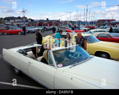 "Raggare" Rockabilly Stil Mann mittleren alten auf einem Parkplatz mit Oldtimer-Chat mit Freunden in einem alten Cabrio Stockfoto