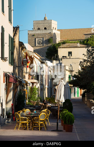 Leere Tische und Stühle vor einer Bar in der Altstadt von Alcudia, Mallorca Stockfoto