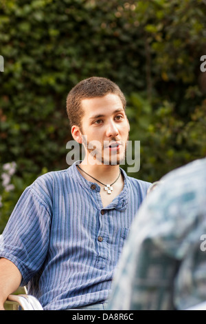 Hübscher junger Mann im Gespräch mit einem Freund im freien Stockfoto