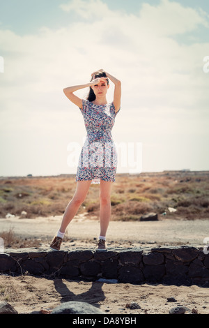 Junge Frau in einem kurzen Vintage Kleid. Dorf Blooming floral print-Kleid Stockfoto