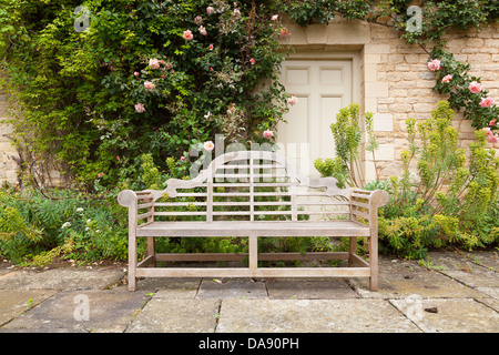 Alte Gartenbank befindet sich in einem gepflegten Garten. Stockfoto