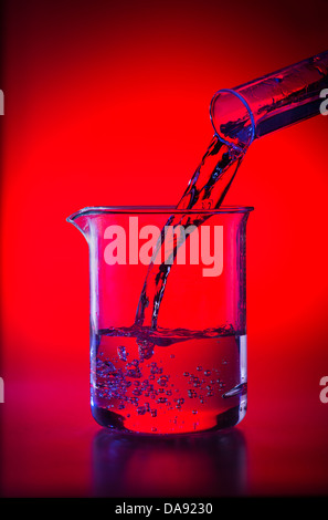 Becherglas im Labor gießt flüssige Chemikalien in Becher Stockfoto