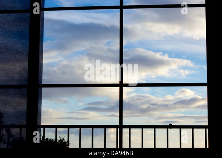 Blauer Himmel mit Wolken, die durch Fenster gesehen. Stockfoto