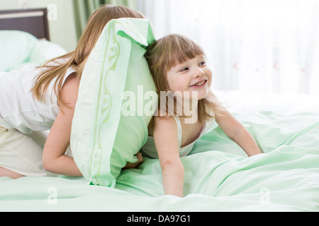 zwei Mädchen spielen im Bett Stockfoto