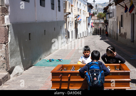 Schülerinnen und Schüler spielen Tabelle Futbol auf einem Tisch im historischen Bezirk von Quito in einem Programm von einer Wohltätigkeitsorganisation eingerichtet. Stockfoto