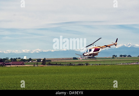 Hubschrauber verwendet, um einen bepflanzten Feld in Colorado, USA Insektizid zuweisen Stockfoto