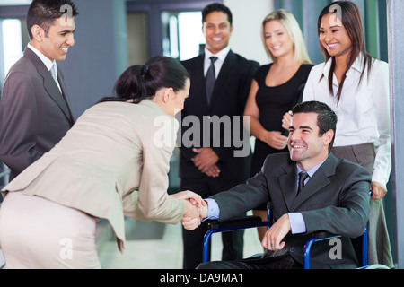 junge Geschäftsfrau Gruß Behinderte Geschäftspartner und team Stockfoto
