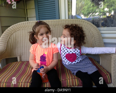 Zwei Cousins auf Wicker Sofa. Stockfoto