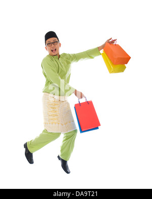 Traditionelle malaiische männlichen Einkaufs- und springen in Freude während Hari Raya Ramadan festival Stockfoto
