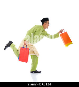 Traditionelle malaiische männlichen Einkaufs- und springen in Freude während Hari Raya Ramadan festival Stockfoto