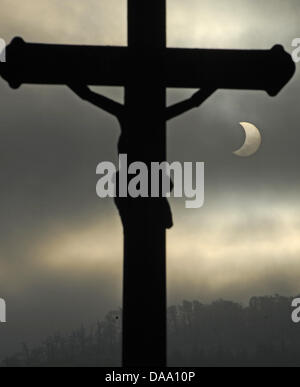 Die Sonne erscheint neben einem Kreuz sichelförmige während einer partiellen Sonnenfinsternis in Freiburg im Breisgau, 4. Januar 2011. Das kosmische Schattenspiel kann in ganz Europa, sowie Teile von Afrika und Asien gesehen. Foto: Patrick Seeger Stockfoto