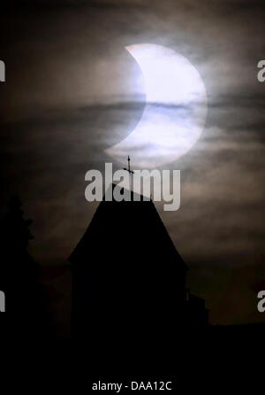 Die Sonne scheint sichelförmige hinter einer Kirche während einer partiellen Sonnenfinsternis auf dem Auerberg bei Bernbeuren, Deutschland, 4. Januar 2011. Das kosmische Schattenspiel kann in ganz Europa, sowie Teile von Afrika und Asien gesehen. Foto: Karl-Josef Hildenbrand Stockfoto