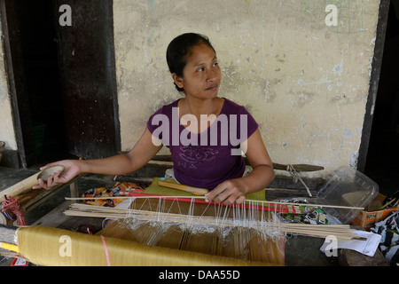 Indonesien, Bali, Sidemen, Frau arbeitet auf einem Webstuhl in ihrem Hof Stockfoto