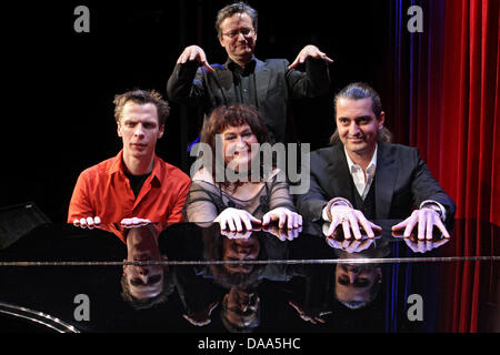 Der Preisträger des Deutschen Kabarett-Preises, Hagen Rether (r) Posiert am Samstag (08.01.2011) in Nürnberg (Mittelfranken) Mit Dem Wiener Kabarettist Klaus Eckel, Gewinner des Förderpreises, Und Lizzy Aumeier, Gewinnerin des Sonderpreises ein Einem Klavierflügel. Im Hintergrund Steht der Gewinner des Vorjahres Und Moderator der Diesjährigen Preisverleihung, Frank Lüdecke. Seit 199 Stockfoto