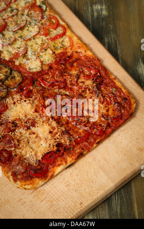 Quadratische hausgemachte Pizza vier Geschmacksrichtungen auf Holzbrett Stockfoto