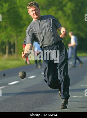 Ein Datei-Bild vom 21. Mai 2002 zeigt Menschen, die spielen des Spiels "Boßeln", eine lokale Spezialität, Boule, auf einer Straße in Ihlowerfehn, Deutschland ähnelt. Nordwest-Deutschland bietet viel Raum für gesunde Aktivitäten für Touristen. Foto: Ingo Wagner Stockfoto