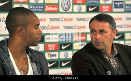 Bremens dauerverletzte Innenverteidiger Naldo (L) schmiegt sich mit sportlicher Direktor Klaus Allofs (R) bei einer Pressekonferenz in Bremen, Deutschland, 14. Januar 2011. Brasilianische Verteidiger Naldo ist zurück zu seinem Haus in Ordnung oder hat seine Knieverletzung von Ärzten in Brasilien, u.a. den Arzt der brasilianischen Nationalmannschaft betreut. Foto: CARMNE JASPERSEN Stockfoto