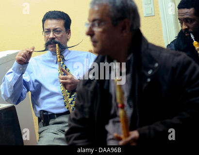 Tunesians Lassaad Dahmani (L-R), Boudaya Abdessatar Und Hedi Sdira sehen Sie die aktuelle News berichtet aus ihrem Heimatland an der tunesischen Gesellschaft "El Kantara" in Berlin, Deutschland, 15. Januar 2011 unterstützen. Bürgerinnen und Bürger treffen sich regelmäßig in den letzten Tagen, um aktuelle Entwicklungen in Tunesien und informieren Sie sich in den Räumen des Vereins. Foto: Britta Pedersen Stockfoto