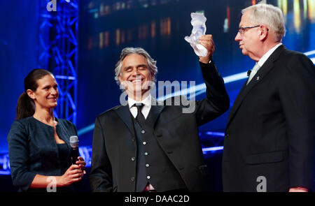 Italienische Tenor Andrea Bocelli lächelt, als er die Humanitarian Award 2013 der weltlichen Serviceorganisation Lions Clubs International (LCI) für seine Andrea Bocelli (ABF) für benachteiligte Kinder in Hamburg, Deutschland, 9. Juli 2013 bekommt. Bocellis Partner Veronica Berti (L) und internationaler Präsident der Lions Clubs International Wayne A. Madden (R) blicken auf. Der Preis ist mit 250.000 Euro dotiert. Foto: ULRICH PERREY Stockfoto