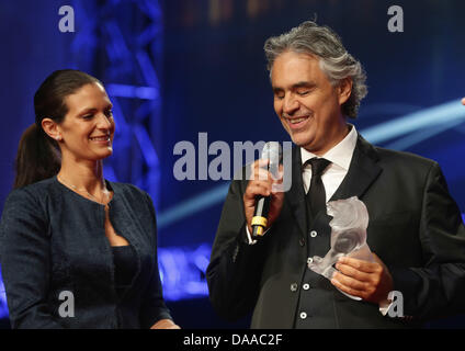 Italienische Tenor Andrea Bocelli lächelt, als er die Humanitarian Award 2013 der weltlichen Serviceorganisation Lions Clubs International (LCI) für seine Andrea Bocelli (ABF) für benachteiligte Kinder in Hamburg, Deutschland, 9. Juli 2013 bekommt. Bocellis Partner Veronica Berti (L) blickt auf. Der Preis ist mit 250.000 Euro dotiert. Foto: ULRICH PERREY Stockfoto