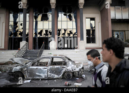 Zuschauer besuchen die geplündert und ausgebrannt an der "Nationaldemokratischen Partei", die regierende Partei von Ägyptens Präsident Hosni Mubarak, in Kairo, Ägypten, 29. Januar 2011 Hauptsitz. Weit verbreitet, Plünderungen und Ausschreitungen haben an diesem Samstag in Ägyptens Hauptstadt weiter. Die Augenzeugenberichte erzählte der Plünderung der Geschäfte geht, während in zwei Bezirken von Kairo, Polizeistationen gestürmt wurden Stockfoto