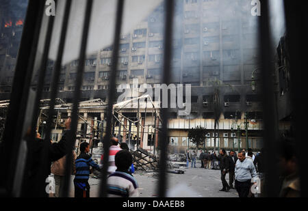 Zuschauer besuchen die geplündert und ausgebrannt an der "Nationaldemokratischen Partei", die regierende Partei von Ägyptens Präsident Hosni Mubarak, in Kairo, Ägypten, 29. Januar 2011 Hauptsitz. Weit verbreitet, Plünderungen und Ausschreitungen haben an diesem Samstag in Ägyptens Hauptstadt weiter. Die Augenzeugenberichte erzählte der Plünderung der Geschäfte geht, während in zwei Bezirken von Kairo, Polizeistationen gestürmt wurden Stockfoto