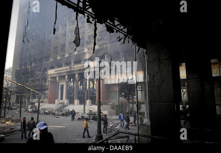 Zuschauer besuchen die geplündert und ausgebrannt an der "Nationaldemokratischen Partei", die regierende Partei von Ägyptens Präsident Hosni Mubarak, in Kairo, Ägypten, 29. Januar 2011 Hauptsitz. Weit verbreitet, Plünderungen und Ausschreitungen haben an diesem Samstag in Ägyptens Hauptstadt weiter. Die Augenzeugenberichte erzählte der Plünderung der Geschäfte geht, während in zwei Bezirken von Kairo, Polizeistationen gestürmt wurden Stockfoto